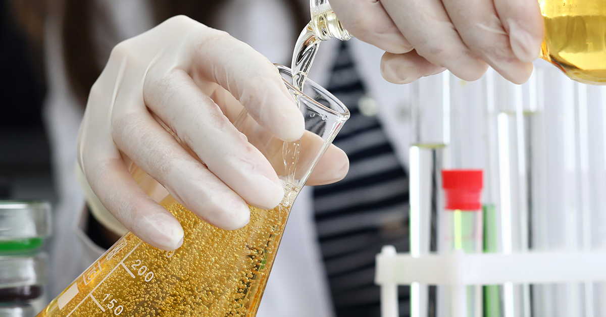 Beer being poured into a conical flask in a laboratory