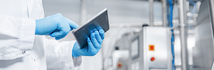 Factory worker using an electronic tablet in factory setting