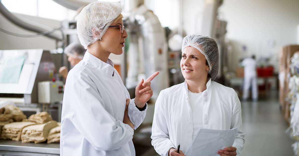 Production workers talking in a food factory setting